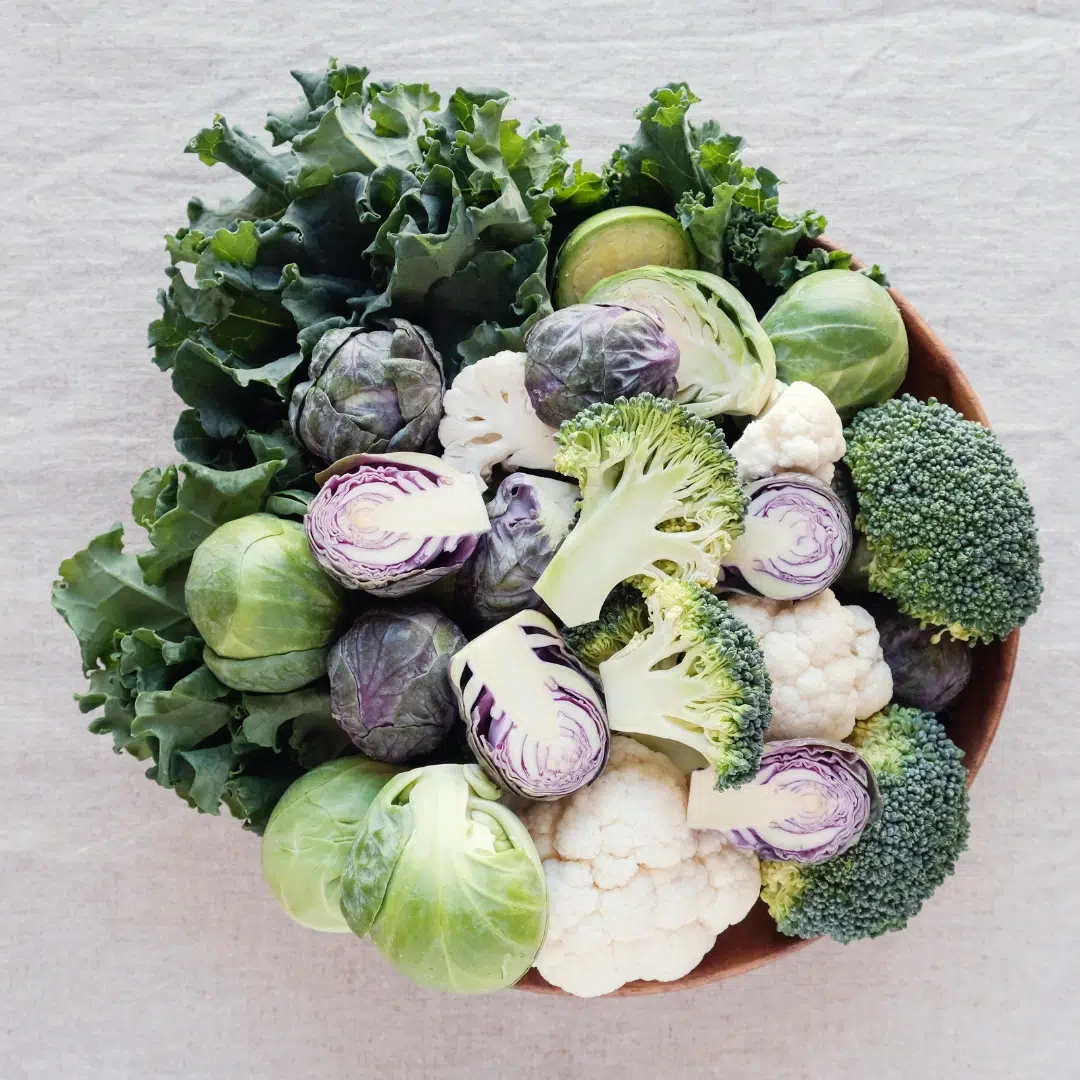 Cruciferous vegetables bowl (broccoli, cauliflower, kale, Brussels sprouts) supporting estrogen metabolism with DIM for hormone balance.